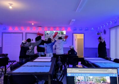 Salle du 1740 pendant un visionnement du match des Canadiens avec écran, tables, chaises et éclairage d’ambiance